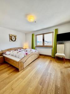 um quarto com uma cama e uma televisão em Wiesen Appartment em Schwarzenberg im Bregenzerwald