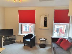 スウィンドンにあるSwindon York Place - EnterCloud9SAのリビングルーム(赤いカーテン、ソファ、テレビ付)