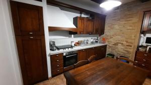 kuchnia z drewnianymi szafkami i drewnianym stołem z drewnianym stołem w obiekcie Appartamento country relax w mieście Montelupone +7 zdjęć