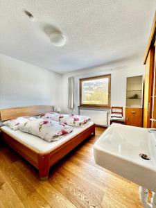 1 dormitorio con 2 camas, lavamanos y bañera en Wiesen Appartment, en Schwarzenberg im Bregenzerwald