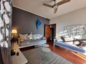 sala de estar con 2 camas y ventilador de techo en LE TERRE DEL DRAGO Apartment en Bergeggi