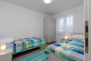 a bedroom with two beds and a window at Apartmani Lejla in Poljica