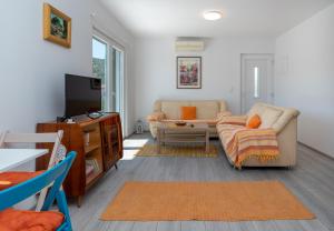 a living room with a couch and a tv at Apartmani Lejla in Poljica