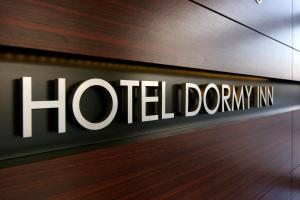 a sign that reads hotel durum inn on a wall at Dormy Inn Kumamoto Natural Hot Spring in Kumamoto