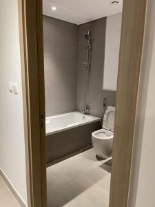 a bathroom with a bath tub and a toilet at Two Bedroom Beach residence in Sharjah