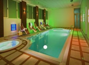 a group of people sitting around a swimming pool at Sweet Home in Belgrade