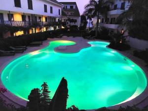 una gran piscina iluminada por la noche en Penthouse with rooftopbar, Fiber WiFi, next to the beach!, en Santa Maria