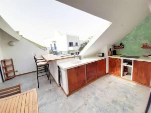 una cocina en el ático con armarios de madera y una mesa en Penthouse with rooftopbar, Fiber WiFi, next to the beach!, en Santa Maria
