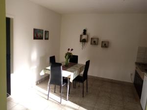 a dining room table with chairs and a vase of flowers at Apartment Buic in Pula