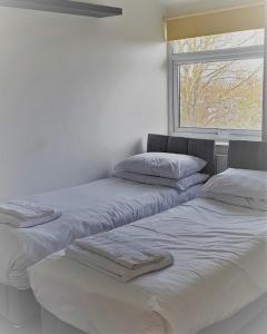 three beds in a room with a window at Swindon Old Town Duplex - EnterCloud9SA in Swindon