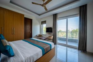 um quarto com uma cama e uma grande janela em The Palms Inn em Gurgaon