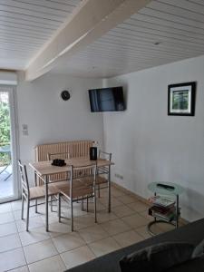 uma sala de estar com uma mesa e cadeiras e uma televisão em Entre Dordogne et Charente en Nouvelle Aquitaine em Porchères