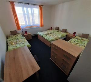 a dorm room with three beds and a window at Ubytování U Janičky in Klíny