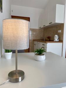 a lamp on a white counter in a kitchen at Guest House Renata in Plomin
