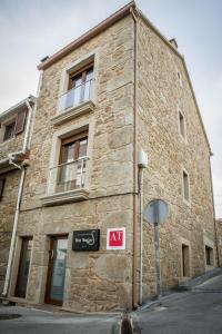 a brick building with a sign in front of it at Apartamentos turisticos HAZ AMIGO in Muxia