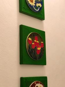 two green plates with flowers on a wall at Oxe Rooms - Quartos no Centro in Salvador