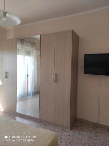 um quarto com uma grande divisória de vidro com uma televisão em TamarHouse Sperlonga Casa Noemi em Sperlonga