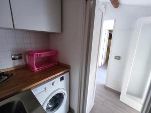 a kitchen with a pink basket on top of a washing machine at Veranda Vista Mare in Syracuse