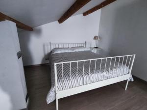 Veranda Vista Mare في سيراكوزا: سرير أطفال أبيض في غرفة بيضاء مع مصباح