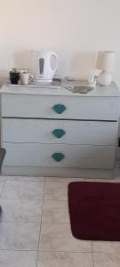 a white dresser with a lamp on top of it at Chambre indépendante à la campagne in Puycalvel Lautrec