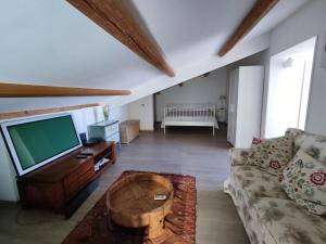 a living room with a couch and a flat screen tv at Veranda Vista Mare in Syracuse