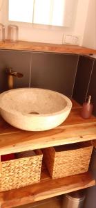 a bathroom sink on a wooden shelf with baskets at Ferienwohnung Renke in Alberode