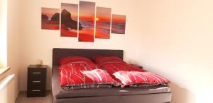 1 dormitorio con 1 cama con 4 cuadros en la pared en Ferienwohnung Renke, en Alberode