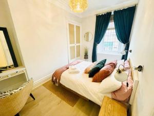 a bedroom with a bed with pillows and a window at Sea Retreats, Whitley Bay, Sleeps 8 in Whitley Bay