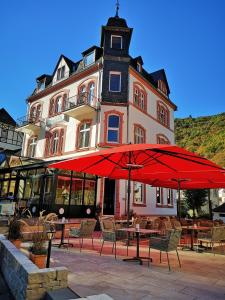 um grande guarda-chuva vermelho em frente a um edifício em Haus Hohenzollern & Haus 'Ambiente em Bad Bertrich