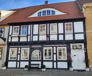 a black and white building with a bench in front of it at Ferienwohnung am Rathaus in Tangermünde