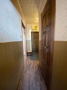 einen leeren Flur mit offener Tür und Holzböden in der Unterkunft Апартаменты in Kineschma