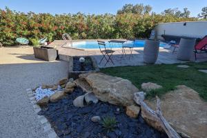 a backyard with a swimming pool and a rock garden at Dépendance en Provence entre Orange et Avignon in Piolenc