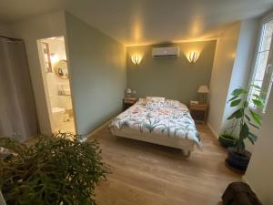 a bedroom with a bed and potted plants in it at Aux portes du Val d'Amour in Sellières