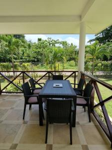 a patio with a table and chairs on a porch at Villa Laure in Grand'Anse Praslin