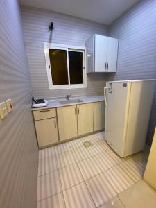 eine kleine Küche mit Spüle und Kühlschrank in der Unterkunft شقق ليالي الشرق للوحدات 3 in Al-Hasa