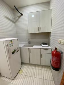 eine Küche mit einem Kühlschrank und einem Hydrant in der Unterkunft شقق ليالي الشرق للوحدات 3 in Al-Hasa