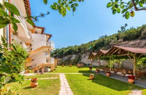 a view of a hotel with a green lawn and a mountain at House Meltemi in Kalamitsi