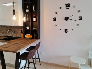 una cocina con un reloj grande en la pared en Sybarix Apartment: Precioso apartamento con vistas al golf y el mar en La Envia