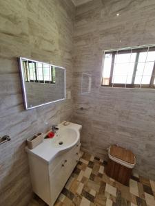 a white bathroom with a sink and a mirror at Villa Laure in Grand'Anse Praslin