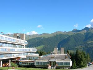a large building with mountains in the background at Marilleva 1400 in Marilleva