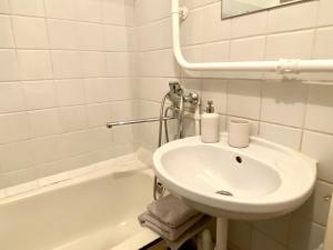 a white bathroom with a sink and a bath tub at Spacious 3-Room Apartment & Residential Parking in Rīga +11 photos