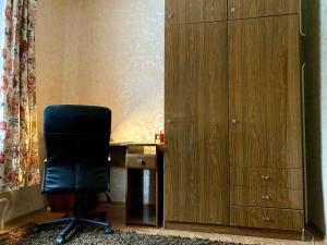 a black chair sitting at a desk next to a cabinet at Spacious 3-Room Apartment & Residential Parking in Rīga