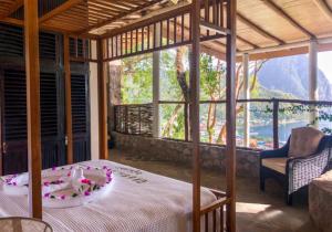Green Fig Resort & Spa في سوفريير: غرفة نوم بسرير وإطلالة على جبل