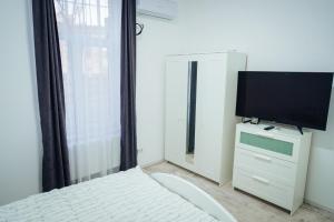 um quarto com uma cama e uma televisão de ecrã plano em Apartament Central Salvo em Turda