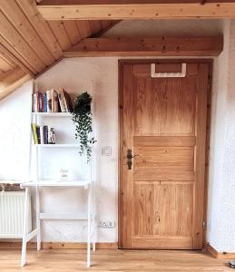 een houten deur in een kamer met een boekenplank bij Chagall - helles und gemütliches Appartement nahe der historischen Altstadt in Mainz