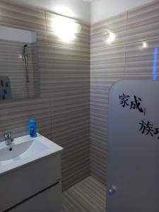 a bathroom with a sink and a shower with writing on the wall at Old Town studio apartment in Larnaka +16 photos