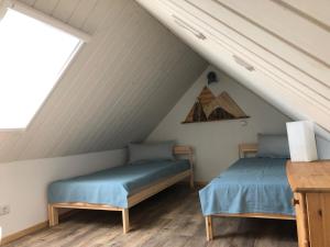 two beds in a attic bedroom with a roof at Quartier Nr.1 in Bad Frankenhausen