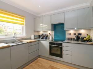 uma cozinha com armários brancos e uma janela em Paradise Place em Perth