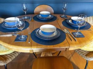uma mesa de madeira com pratos e copos de vinho em Paradise Place em Perth