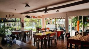 a restaurant with tables and chairs and windows at Pousada Sol Dourado in Jijoca de Jericoacoara